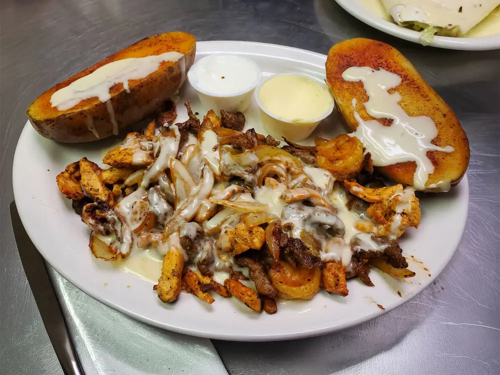A plate of food featuring a serving of potatoes alongside a rich side of gravy.