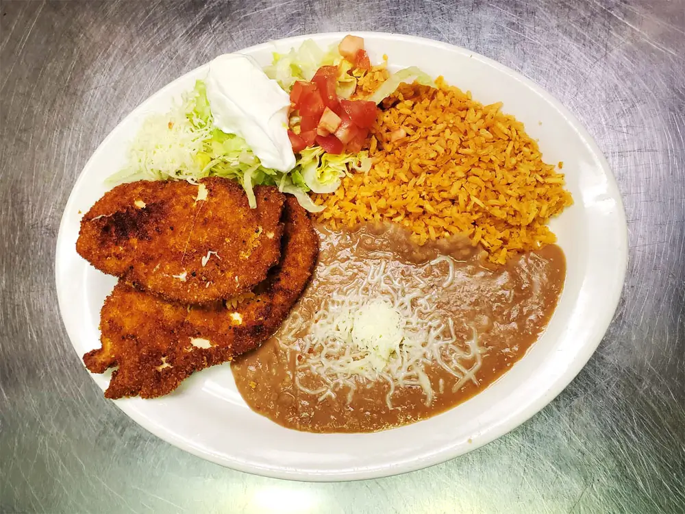A plate of rice, beans, and meat, arranged appetizingly for a hearty meal.